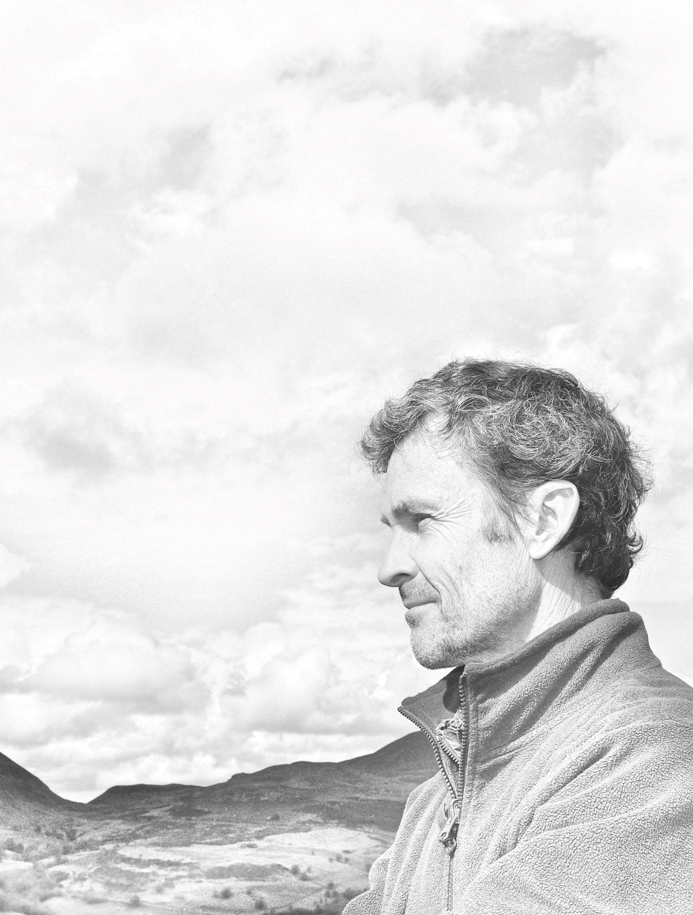 David North sanding on a hill top, back and white